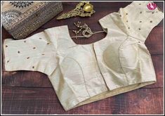 This is a cream color raw silk blouse with golden chumki work. This has a beautiful back neck with dori in the back and has a standard front opening. It fits size 40. It is a classy blouse perfect to pair with silk sarees. Size: 40 Please note: Color may vary slightly from the picture. Loose threads and pulled threads are common in embroidered clothing and it is not a defect. Elegant Art Silk Blouse With Dori Work, Elegant Semi-stitched Dola Silk Blouse, Elegant Unstitched Dola Silk Blouse, Elegant Dori Work Blouse In Dola Silk, Elegant Dola Silk Blouse With Dori Work, Raw Silk Blouse For Wedding, Gold Art Silk Blouse For Wedding, Raw Silk Wedding Blouse, Elegant Dola Silk Blouse For Navratri