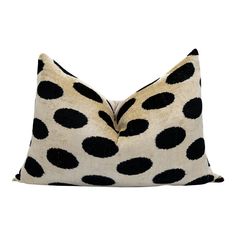 a black and white polka dot pillow on a white background