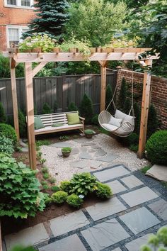 a backyard with a hammock, swing chair and stone path leading to the back yard