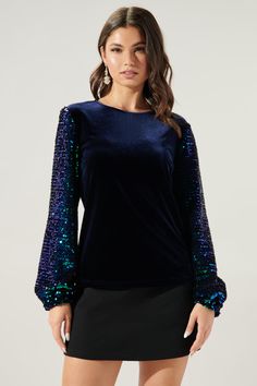 Live out your mermaid dreams in this mixed texture top. It maintains a standard fit with long sequin balloon sleeves and a velvet bodice. For the perfect night out look, tuck it into your favorite bottoms and pair with strappy sandals.- Velvet bodice- Sequin sleeves- Standard fit- Keyhole- Color: Navy MultiSize + Fit - Model is 5'9" and wearing size XS- Measurements taken from size S - Chest: 36"- Length: 24 1/2" FabricSelf: 92% Polyester, 8% Spandex, Contrast: 100% Polyester, Lining: 100% Polye Formal Tops, Mermaid Dreams, Sequin Sleeve, Glitter Top, Perfect Night, Navy Velvet, Velvet Blouses, Velvet Top, Velvet Tops