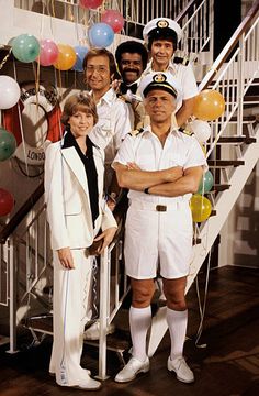 a group of people standing next to each other in front of some stairs and balloons