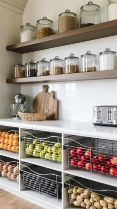 a kitchen with open shelves filled with fruits and veggies on top of it