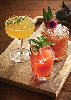 three different types of drinks on a wooden tray