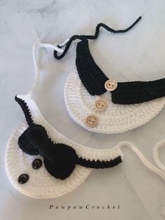 two crocheted purses with buttons on them sitting on top of a table