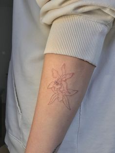 a woman's arm with a flower tattoo on the left side of her arm