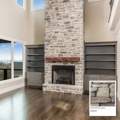 an empty living room with wood floors and a stone fireplace in the center, surrounded by windows