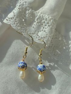 Dainty, trendy, hypoallergenic gold drop earrings with porcelain blue and white beads, gold finishes, and imperfect pearls. Blue And Pearl Earrings, Dainty Beaded Earrings, Blue Dangling Beads Jewelry, Blue Dangle Pearl Drop Earrings, Blue Pearl Charm Earrings As Gift, Blue Earrings With Dangling Beads, Handmade Blue Pearl Earrings, Handmade Blue Dangle Pearl Earrings, Porcelain Beads Jewelry