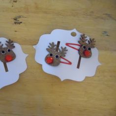 two reindeer head brooches on top of a white paper plate with red nose and antlers