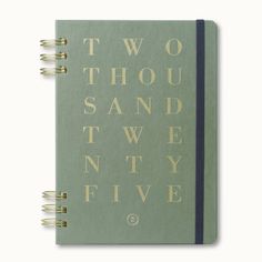 a green notebook with two thousand words written in gold on the front and back cover