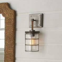 a light fixture mounted on the side of a white wall next to a mirror and window