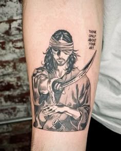 a man with a pirate tattoo on his arm holding a knife and looking at something