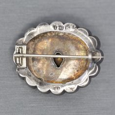 "Victorian Silver and Paste Engraved Brooch, 1885 English Silver C Clasp Brooch Pin, Antique Birmingham Silver Paste Brooch, Antique Gift This remarkable Victorian brooch can be dated to Birmingham, 1885. The brooch features scrolling patterns of engraving on a scalloped silver oval with starburst highlights at four points. The center stone is foil back paste and is set with claw-like prongs surrounding the stone. The stone is clear with a reflective tint. The piece is fully hallmarked. It measu Ornate Oval Engraved Brooches, Victorian Hallmarked White Gold Brooches, Victorian Hallmarked White Gold Brooch, Antique Oval Engraved Brooches, Victorian Oval Hallmarked Brooches, Antique White Gold Collectible Brooches, Antique Cabochon Brooches For Anniversary, Antique Engraved Collectible Brooches, Vintage White Gold Oval Brooches