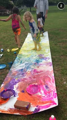 two children are playing on an art project in the grass with their dad and father