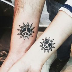 two people with matching tattoos on their wrist and arm, both have peace signs in the middle