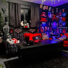 a living room filled with red and black couches next to a window covered in halloween decorations