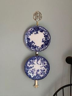 two blue and white plates hanging on the wall