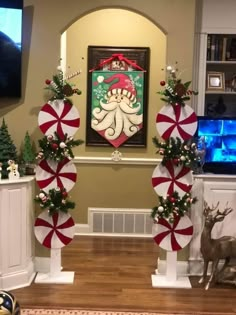 some candy canes and christmas decorations in front of a painting on the wall above a fireplace