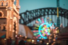 an amusement park with ferris wheel and bridge in the background at night, blurry image