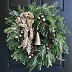 a wreath on the front door is adorned with evergreen, pine cones and gold bells