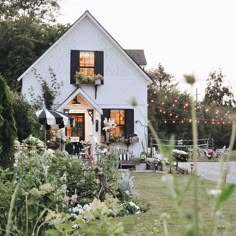 a white house surrounded by greenery and lights