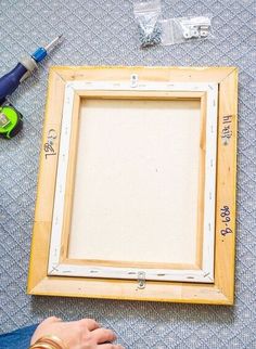 a person is working on an unfinished frame with glue and other crafting supplies around it