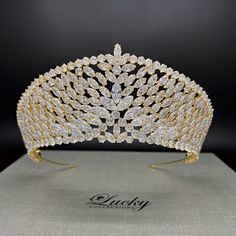 A breathtaking tiara designed in line with elegant royal crowns. Hundreds of perfectly cut high-quality Cubic Zirconia enhance the curvature of this piece. A single solitaire marquise zirconia completes the upper slanted row.  Available on www.ProBridalUSA.com *Handcrafted with highest quality Zirconia jewels and rhodium plated to prevent tarnish and scratch. *High Quality Teardrop, Marquise and Round CZ gems. *Measures 2.875 inches in center  *Ideal for Wedding, Bridal Hair, Anniversary, Quince Regal Gold Headpiece For Wedding, Regal Structured Crown Wedding Headpiece, Regal Gold Headpieces For Weddings, Regal Gold Wedding Headpiece, Regal Wedding Headpiece With Structured Crown, Regal Structured Crown Headpiece For Wedding, Regal Tall Crown Headpieces For Wedding, Regal Tall Crown For Wedding, Regal Gold Crown For Wedding