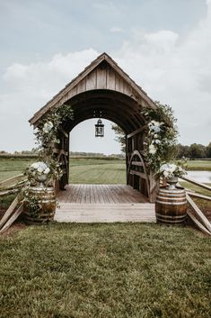 a wooden structure with flowers and vines on the front entrance to a farm wedding venue