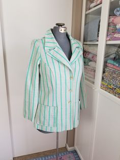 "Cute little blazer style jacket. The fabric is a poly knit that has shades of green and pink stripes. Kinda reminds me of a watermelon! Has two patch pockets on the front, and 3 buttons. Label read, \"West Coast Fashions California\" Condition: Fair to good, but definitely wearable! There is a bit of verall pilling, and a few pulls in the fabric, which isn't that noticeable. Measurements Bust: up to 41\" Length: 23\"" Spring Retro Blazer For Tailoring, Retro Spring Blazer With Lapel Collar, Retro Lapel Collar Blazer For Spring, Retro Blazer With Lapel Collar For Spring, Striped Retro Outerwear For Work, Vintage Striped Outerwear For Spring, Retro Striped Outerwear For Work, Retro Green Blazer For Workwear, Retro Blazer With Buttons For Spring