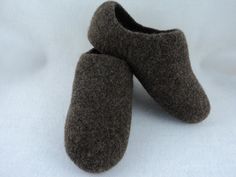 two brown slippers sitting on top of a white sheet