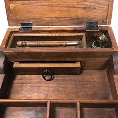 an open wooden box with two metal objects inside