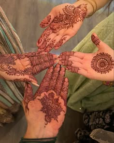 four hands with henna designs on them