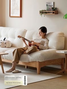 a woman sitting on a couch playing an ukulele