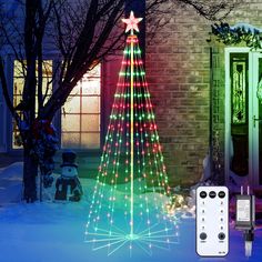 a lighted christmas tree next to a remote control