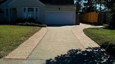 a driveway leading to a house with a gate