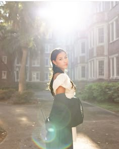 a woman is walking down the street with her hand on her hip and looking at the camera