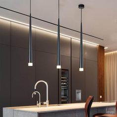 a kitchen with three lights hanging from the ceiling and two chairs in front of it