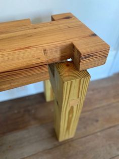 a wooden bench sitting on top of a hard wood floor