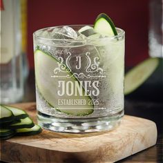 cucumber slices are placed on the edge of a glass that is sitting on a cutting board