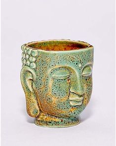 a ceramic cup with a face on it