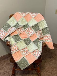 a baby quilt sitting on top of a wooden chair