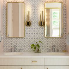 a bathroom with two sinks and mirrors on the wall