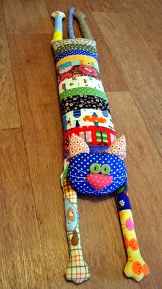 a multicolored stuffed animal laying on top of a wooden floor