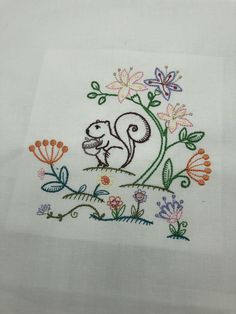 embroidered squirrel on white linen with colorful flowers