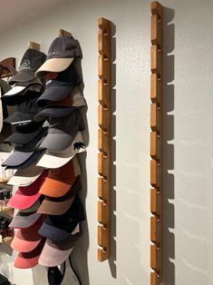 several hats are hanging on the wall next to two wooden racks with hat hooks