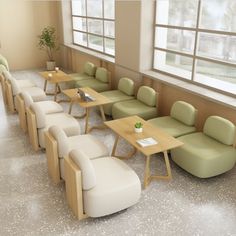 an empty waiting room with green and white chairs, tables and couches on the floor