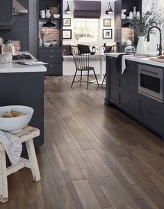 a kitchen with wooden floors and gray cabinets