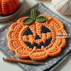 an orange crocheted pumpkin sitting on top of a table