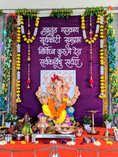 an elephant statue sitting in front of a purple backdrop with words written on the wall