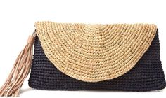 a straw clutch bag with tassels on the front and side, sitting on a white background