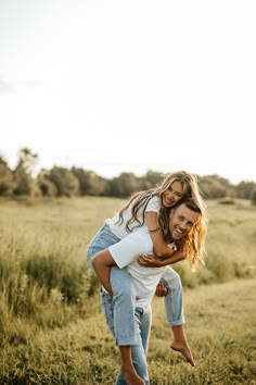 a man carrying a woman on his back in a field